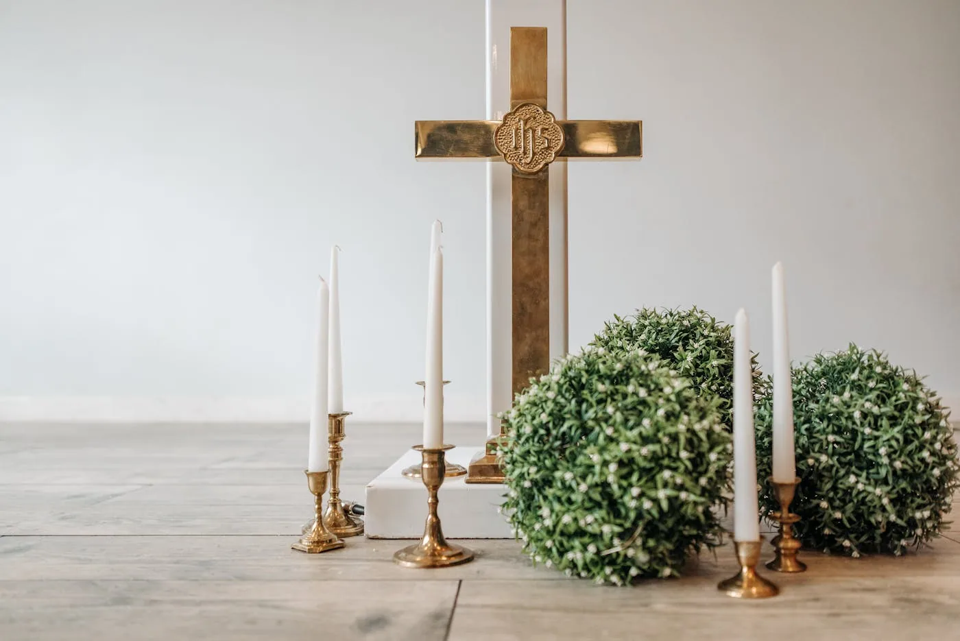 Catholic memorial setup with brass cross and white candles
